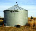 Farmer pulling on cable to open grain bin lid