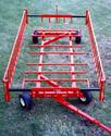 The four-wheeled implement consisting of spaced square rods on which the bales lay, 3-feet-high â€˜feeding fenceâ€™ running the length of each side, and a square rod front and rear that adjust the feeding fence distance.