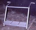 About 18 inches above the hanging step that is welded to left and right 30-degree-sloped arms is another metal pipe also welded to the arms, which are bent parallel to the step and their ends  bent to serve as fastening hooks.